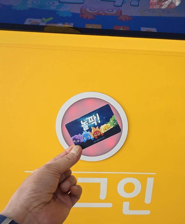 RFID 카드를 게임기에 태깅하는 손